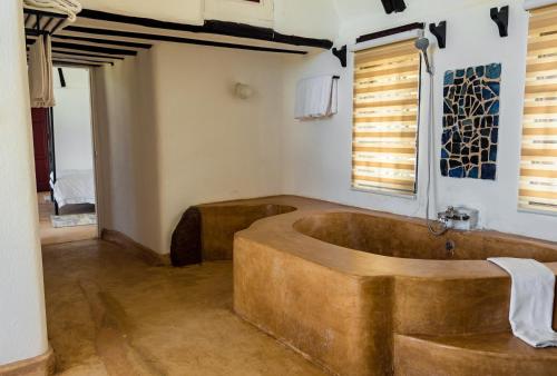 a bathroom with a wooden tub in a room at Maanzoni - Ndoto House ,Athi River by Nest & Nomad in Machakos
