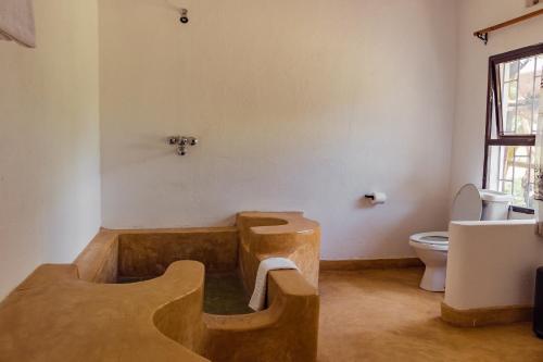 a bathroom with a wooden tub and a toilet at Ndoto House-Maanzoni ,Athi River by Nest & Nomad in Machakos