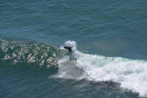 a man riding a wave on a surfboard in the ocean at Ocean Front Condo @ Las Olas Grand in Rosarito