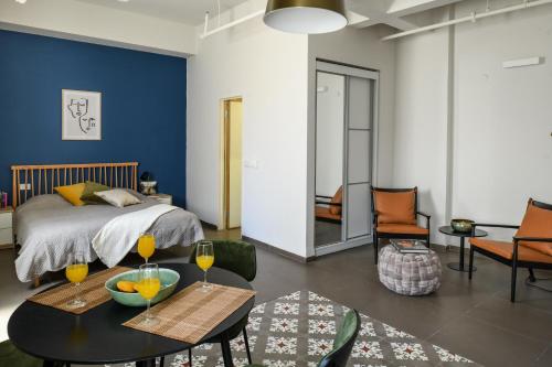 a bedroom with a bed and a table with drinks on it at The Printhouse - Downtown Boutique Apartments by Sea N' Rent in Haifa