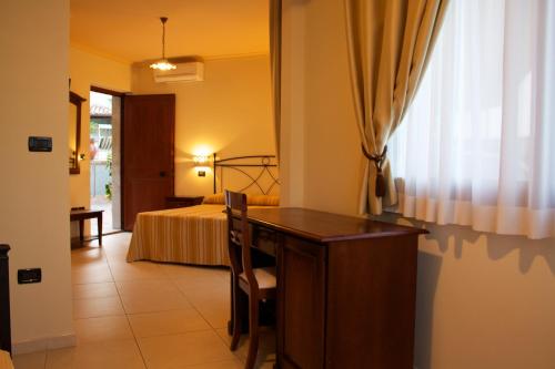 a hotel room with a desk and a bed at Villa Cristina in Giardini Naxos