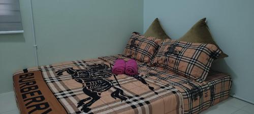ein Bett mit rosa Hausschuhen darüber in der Unterkunft Casa Klebang @ Ipoh homestay in Chemor