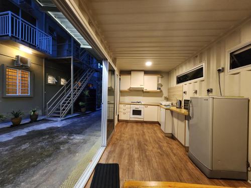 een keuken met een koelkast en een trap erin bij Golden Lodge in Tanah Rata