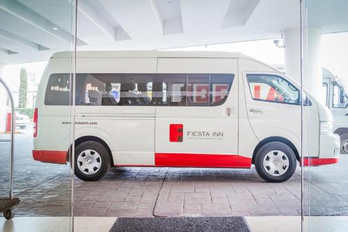 a white and red van parked in a building at Fiesta Inn San Luis Potosi Glorieta Juarez in San Luis Potosí