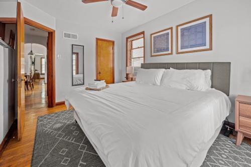 a bedroom with a large white bed with a ceiling fan at 1 bedroom-City Livin in Saint Louis