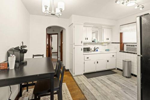 eine Küche mit weißen Schränken und einem schwarzen Tisch in der Unterkunft Cozy 1-bedroom apartment with free parking in Saint Louis