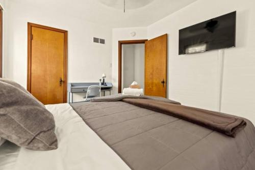 a bedroom with a large bed with a television on the wall at Cozy 1-bedroom apartment with free parking in Saint Louis