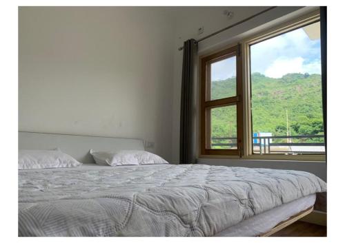 - une chambre avec un grand lit et une fenêtre dans l'établissement Tamanna House., à Morni