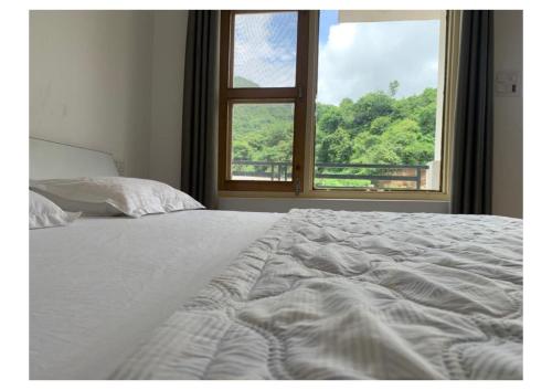 - une chambre avec un lit blanc et une fenêtre dans l'établissement Tamanna House., à Morni
