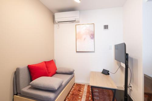 a living room with a couch and a tv at The Sanctus Ebisu in Tokyo