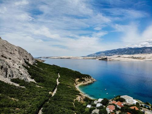 a view of a large body of water with houses at Villa Pag Dubrava Relax with Pool in Pag