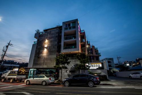 a tall building with cars parked in front of it at Cheonjiyeon Hotel in Seogwipo
