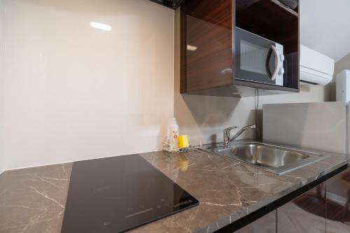 a kitchen with a sink and a microwave at The Sanctus Ebisu in Tokyo