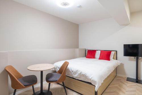 a bedroom with a bed with a table and chairs at The Sanctus Ebisu in Tokyo