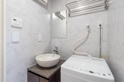 a white bathroom with a sink and a white sink at The Sanctus Ebisu in Tokyo