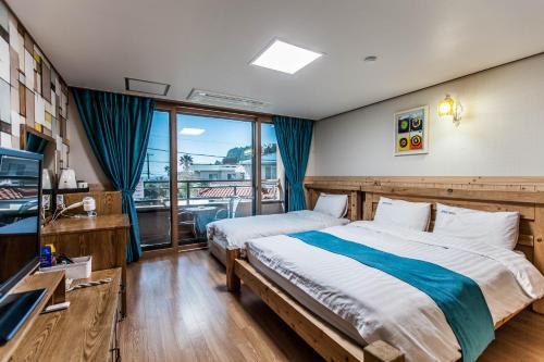 a bedroom with a bed and a large window at Cheonjiyeon Hotel in Seogwipo