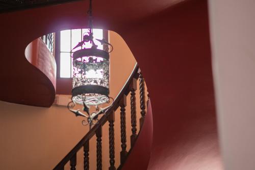 a chandelier is hanging from a stairway at Hotel Casa Colon in San José