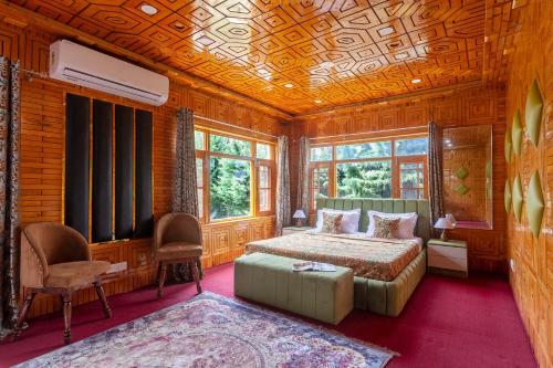 - une chambre avec un lit, un canapé et des fenêtres dans l'établissement StayVista at Buhayra Lakefront, à Srinagar
