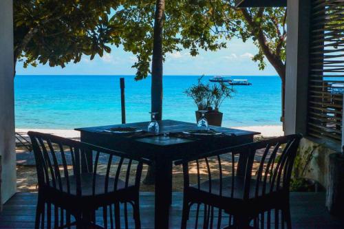 a table with chairs and a view of the ocean at Japamala Resort by Samadhi Age 12 and Above Only in Tioman Island