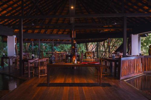 a restaurant with a table and chairs on a wooden floor at Japamala Resort by Samadhi - Adults Only in Tioman Island