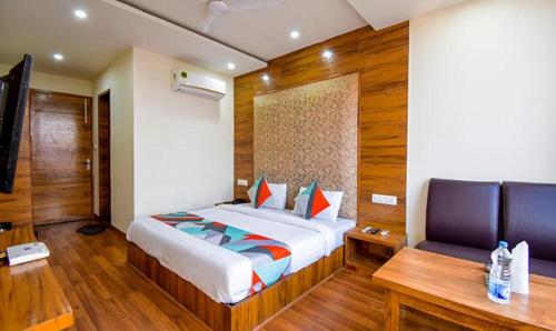 een slaapkamer met een bed, een tafel en een bank bij FabExpress Black Diamond in Zirakpur