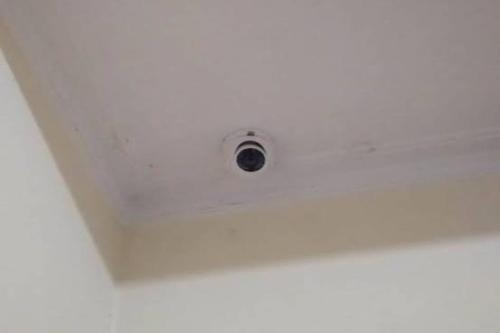 a white ceiling with a security camera on it at Hotel O Lavina Guesthouse in Dumai