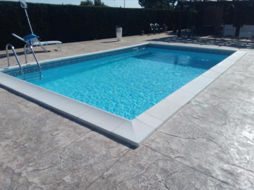 uma piscina rectangular com um esbranquiçador à volta em Villetta La Melissa em Cutrofiano
