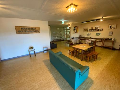 a living room with a couch and a table at Mashuko Youth Hostel in Teshikaga