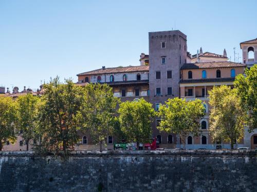 a building with trees in front of a body of water at Alto Apartment in Rome