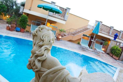 a statue in front of a swimming pool at Villa Cristina in Giardini Naxos