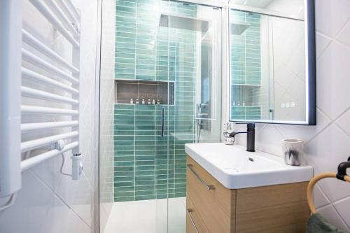 een badkamer met een wastafel en een glazen douche bij Paris naturellement in Parijs