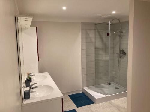 a bathroom with two sinks and a shower and a tub at LA FINNOISE in Fains-les-Sources