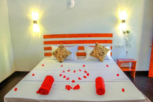 a bedroom with a bed with red hearts on it at Sigiri Enaya Cottage in Sigiriya