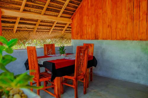 tavolo e sedie in una stanza con tetto di Sigiri Enaya Cottage a Sigiriya