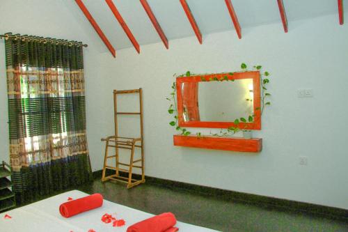 a room with a mirror on the wall and a table at Sigiri Enaya Cottage in Sigiriya