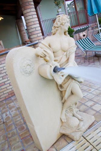 a statue of a man sitting on top at Villa Cristina in Giardini Naxos