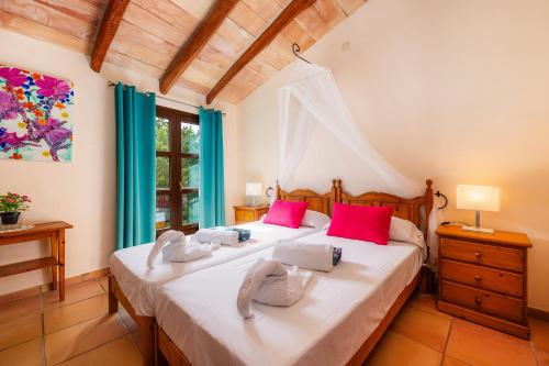 a bedroom with two beds with pink pillows at Finca Son Favar Capdepera in Capdepera