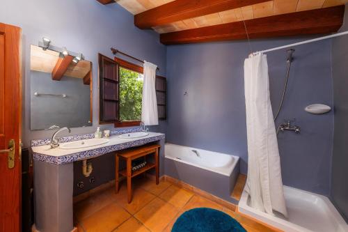 a blue bathroom with a sink and a tub and a bath tub at Finca Son Favar Capdepera in Capdepera