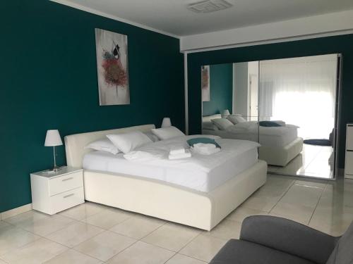 - une chambre avec 2 lits et un mur vert dans l'établissement Apartments Villa Lili, à Umag