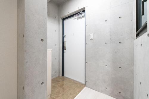 a pivot door in a room with concrete walls at Ferio Kamata II in Tokyo