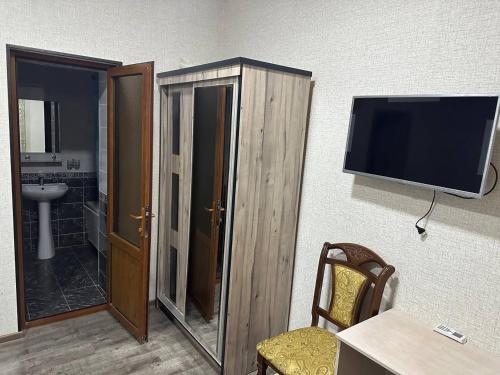 een kamer met een tv en een tafel en een stoel bij REAL TASHKENT Inn in Tasjkent