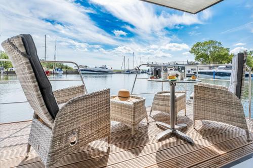 a deck with two chairs and a table on a boat at Marina Martinshafen in Sassnitz