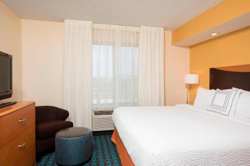 Pokój hotelowy z dużym łóżkiem i telewizorem w obiekcie Fairfield Inn & Suites by Marriott Bloomington w mieście Bloomington