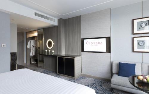 a hotel room with a bed and a couch at Centara Grand At CentralWorld in Bangkok