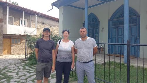a man and a woman standing in front of a house at Lahij Rashad Ismayilov Hotel in Lahıc