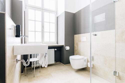 La salle de bains est pourvue de toilettes, d'un lavabo et d'une douche. dans l'établissement Bildungs- und Tagungshaus Liborianum, à Paderborn