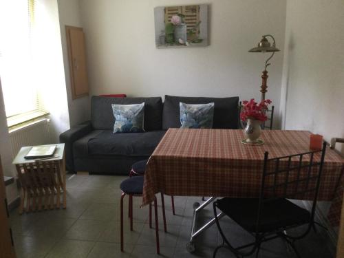 a living room with a table and a couch at Gîte côté jardin in Ingersheim