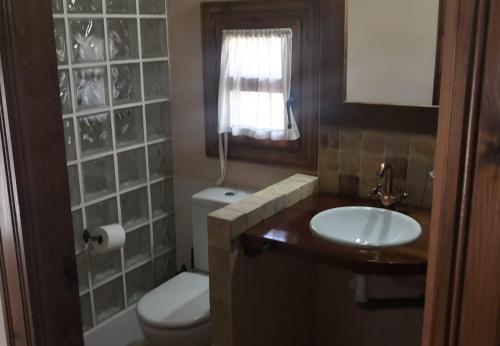 La salle de bains est pourvue d'un lavabo, de toilettes et d'une fenêtre. dans l'établissement La Casa Amarilla, à Totana