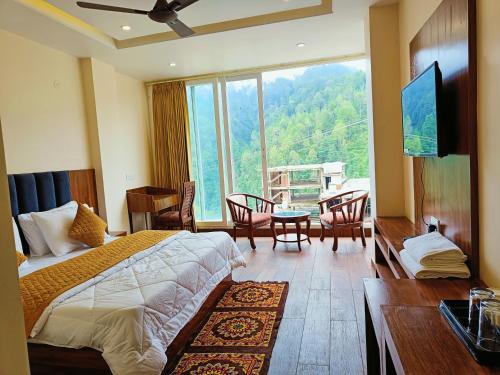um quarto de hotel com uma cama e uma grande janela em The Jade Mountain Dalhousie em Dalhousie