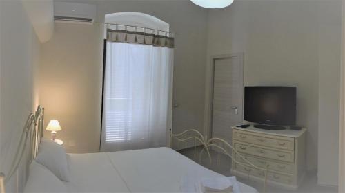 una camera con letto e televisore su un comò di le antiche mura-rooms-private toilet a Milazzo